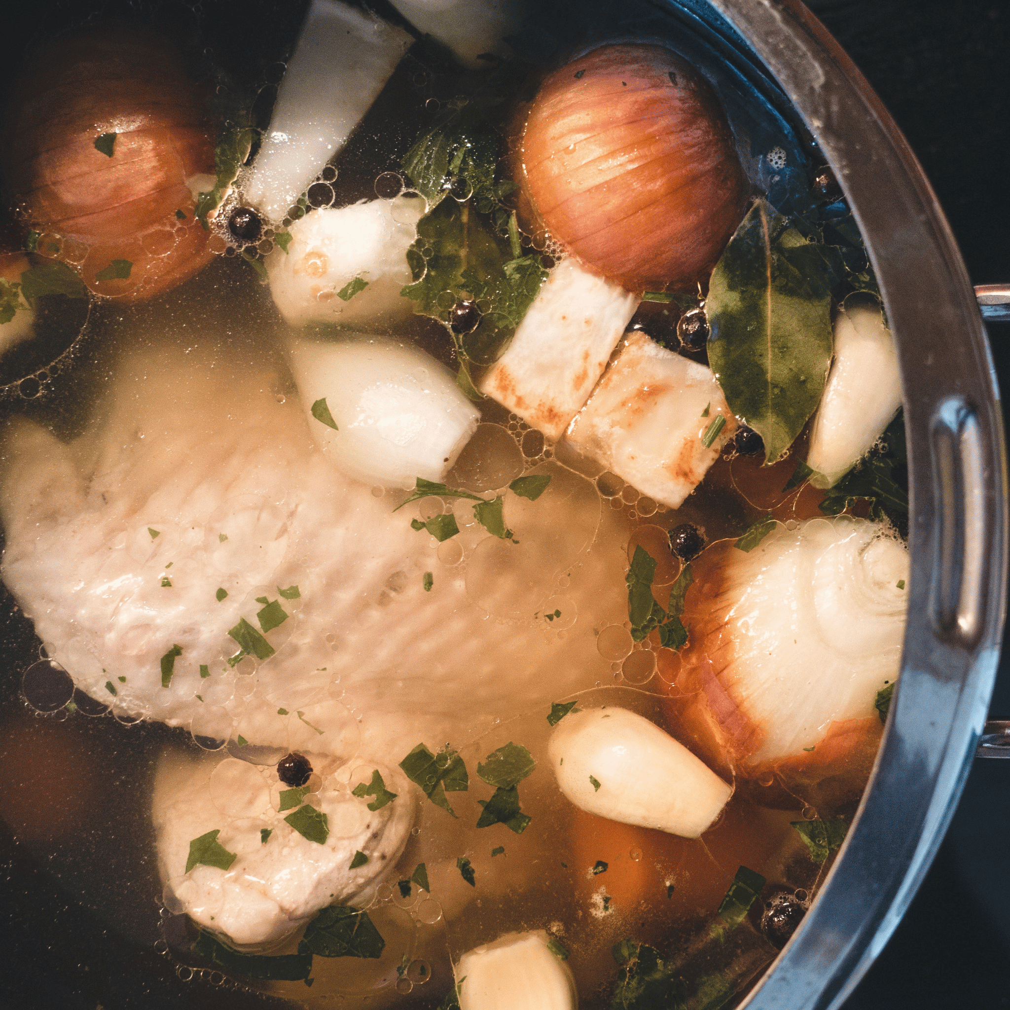 Meaty chicken backs simmering in a pot with vegetables for broth