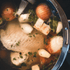Meaty chicken backs simmering in a pot with vegetables for broth