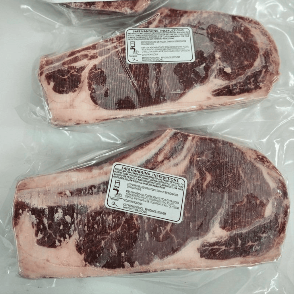 Two packages of raw beef with handling instructions labels on a white background