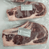 Two packages of raw beef with handling instructions labels on a white background
