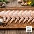 Raw chicken wings on a wooden cutting board with seasonings and a brand logo in the corner.