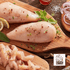 Raw chicken breasts on a wooden board with herbs and spices, Campo Lindo logo visible.
