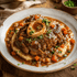 Plated dish of bison osso buco with carrots and mashed potatoes on a wooden table.