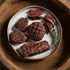 Plated grilled bison with a sprig of rosemary on a wooden surface