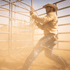 Hightail ranch Cowboy holding a lasso in a fenced area with a warm, golden light.
